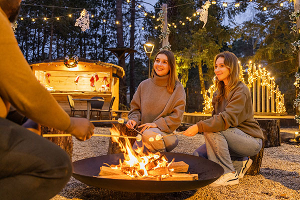 Mensen rondom een kampvuur op Center Parcs Les Hauts de Bruyères